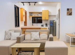 a living room with a couch and a kitchen at The Hidden Escape in Sampong