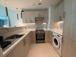 una cucina con lavatrice, lavandino e lavastoviglie di Highend Luxury 7 Palm Residence in Palm Jumeriah a Dubai Altre 25 foto