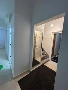 a room with a mirror and a white wall at Appart Hoceima F4 Climatisé Central in Al Hoceïma