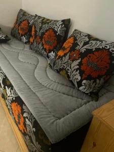 a bed with two pillows on top of it at Appart Hoceima F4 Climatisé Central in Al Hoceïma