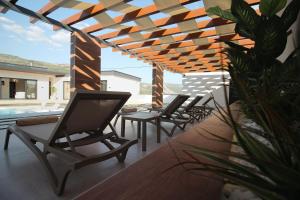 una fila de sillas en un patio con piscina en Golden View Villa Sauna & Spa, en Blagaj