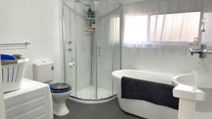 a white bathroom with a shower and a toilet at Reel 'Em Inn in Wauraltee +6 photos