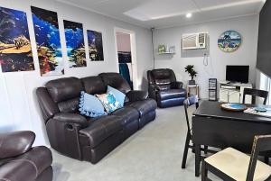 a living room with a leather couch and a table at Reel 'Em Inn in Wauraltee