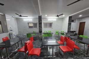 a dining room with tables and red chairs at Om Sri Vigneshwara Palani Grand Hotel in Hyderabad