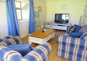 a living room with two couches and a tv at Serenity By The Sea in Port Hughes