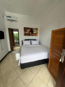 a bedroom with a large bed in a room at Canggu 77 Guest House in Badung
