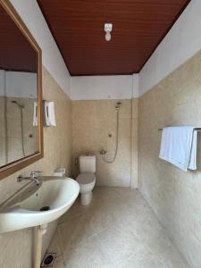 a bathroom with a sink and a toilet and a shower at Canggu 77 Guest House in Badung +10 photos