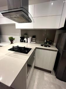 a white kitchen with a stove and a sink at Apto 305 Distrito 90 in Barranquilla +11 photos