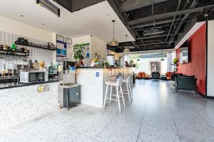 a kitchen with a counter and chairs in a room at 不负韶华青年旅馆 Youth Hostel in Suzhou