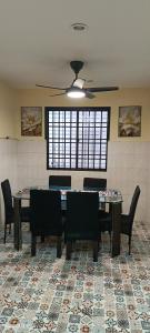 a dining room with a table and chairs and a ceiling fan at Alfian Homestay in Johor Bahru
