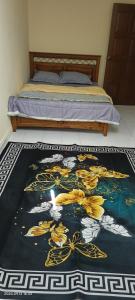 a bedroom with a bed with a black and yellow rug at Alfian Homestay in Johor Bahru