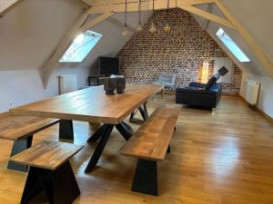 a large room with a wooden table and benches at Côté Gîtes Cassel in Cassel
