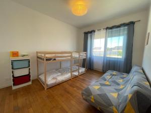 a bedroom with a bunk bed and a window at Ty Gwer proche des plages de Pors Carn & La Torche - 8 personnes in Penmarcʼh