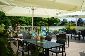 a patio with tables and chairs and umbrellas at Hotel Swing in Krakow +64 photos