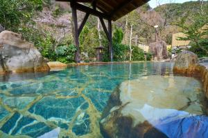 a swimming pool with rocks in the water at 下田温泉 湯本の荘 夢ほたる in Amakusa +42 photos