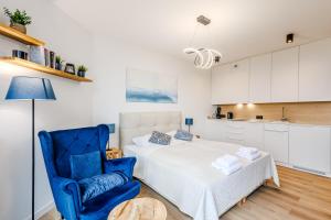 una camera da letto con un letto e una sedia blu di Apartamenty PINEA tuż przy plaży a Pobierowo Altre 174 foto