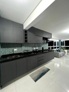a kitchen with black cabinets and a white floor at Summer Apartment in Porto De Galinhas
