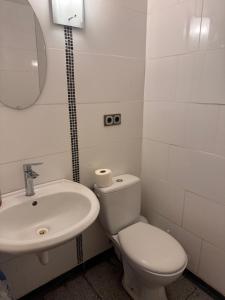 a white bathroom with a toilet and a sink at Familyroom 6 P Free WiFi Gemeinschaftsbad in Hausbreitenbach