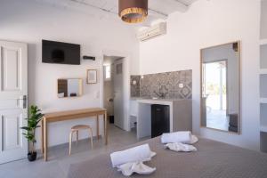 a white living room with a table and a desk at Harokopou Studios in Koufonisia