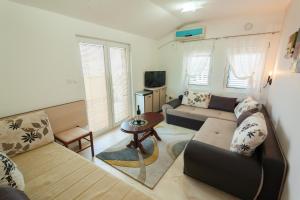 ein Wohnzimmer mit einem Sofa und einem Tisch in der Unterkunft Apartments Mila Krimovica in Budva