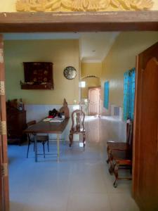 a living room with a table and chairs and a clock on the wall at Siem Reap Local Stay in Phumĭ Réach Born