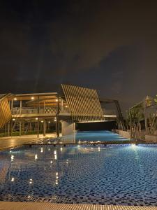 a large swimming pool in front of a building at night at Alora Homestay in Kajang