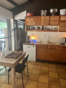 a kitchen with wooden cabinets and a table and a table and chairs at Maison de vacances Namasté in Mérignac