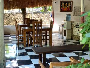 a restaurant with wooden tables and chairs and a checkered floor at Gelih Bungalow Nusa Penida in Nusa Penida