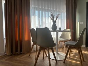 a dining room with a table and chairs and a vase at Harmony B&B in Fălticeni