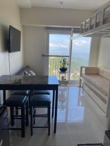 a dining room with a table and chairs and a balcony at Balay Nuevo in Kaybagal