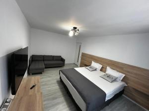 a bedroom with a large bed and a couch at Mangalia Cozy Suite in Mangalia