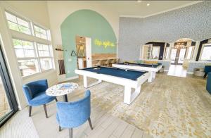 Dos mesas de billar en una habitación con sillas azules. en 3 Bedroom Luxury Condo with Resort Pool, Game Room, and Gym, en Panama City Beach 28 fotos más