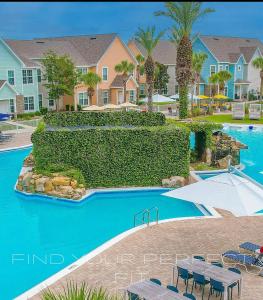 Una piscina de resort con mesas, sillas y casas. en 3 Bedroom Luxury Condo with Resort Pool, Game Room, and Gym, en Panama City Beach