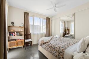a bedroom with a bed and a chair and a window at Cockatoo EcoHouse in Witchcliffe