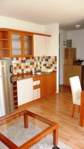 シオーフォクにあるSirály Apartmanのキッチン(ステンレス製の冷蔵庫、テーブル付)