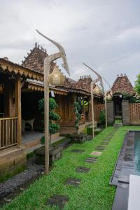 a row of cottages with a pool in the yard at Taruchi 4 bedrooms villa in Kesiman