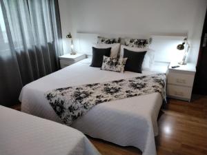 a bedroom with two beds with white sheets at Buddies Charm House in Aveiro