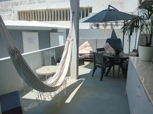 a balcony with a hammock and a table and a couch at Buddies Charm House in Aveiro