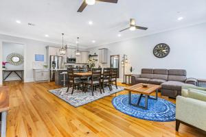 ニューオーリンズにあるHosteeva Stunning 4 BR Condo w Pool Steps to St Charles Aveのソファとテーブルのあるリビングルーム