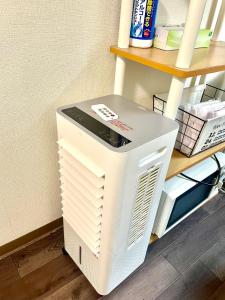 a computer sitting on the floor next to a shelf at Tokyo 2beds room in Shinjuku Sanchome in Tokyo