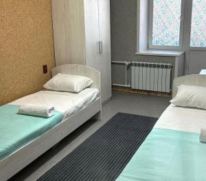 a room with two beds and a window at Silk Way in Semey