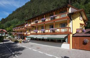 a building with flowers on the balconies on a street at Hotel Zanon in Ziano di Fiemme