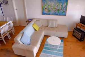 a living room with a couch and a table at The Little White House in Port Vincent