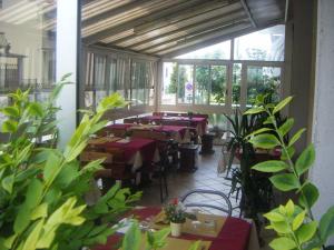 un grupo de mesas en una habitación con plantas en Locanda La Rotonda, en Montale