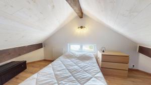 a bedroom with a bed and a dresser in a attic at Pagotin de charme à Métabief in Métabief