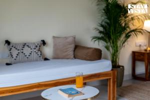 Una habitación con una cama y un vaso de jugo de naranja sobre una mesa. en StayVista at Silver Leaf with Lawn & Pool, en Alibaug