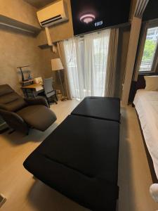 福岡市にあるStar Residence2 春吉中洲のベッドとソファと椅子のある寝室