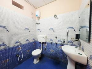 a bathroom with a toilet and a sink at Resort Garden Retreat Seaview in Mandarmoni +70 photos