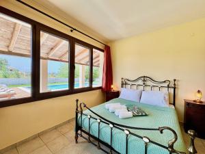 a bedroom with a bed with two towels on it at Beachfront Villa Calypso with private pool by DadoVillas in Acharavi +37 photos