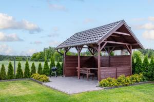 a wooden gazebo with a grill in a garden at Komfort i spokój blisko natury - Apartamenty i pokoje ARKO in Ostrowo +36 photos
